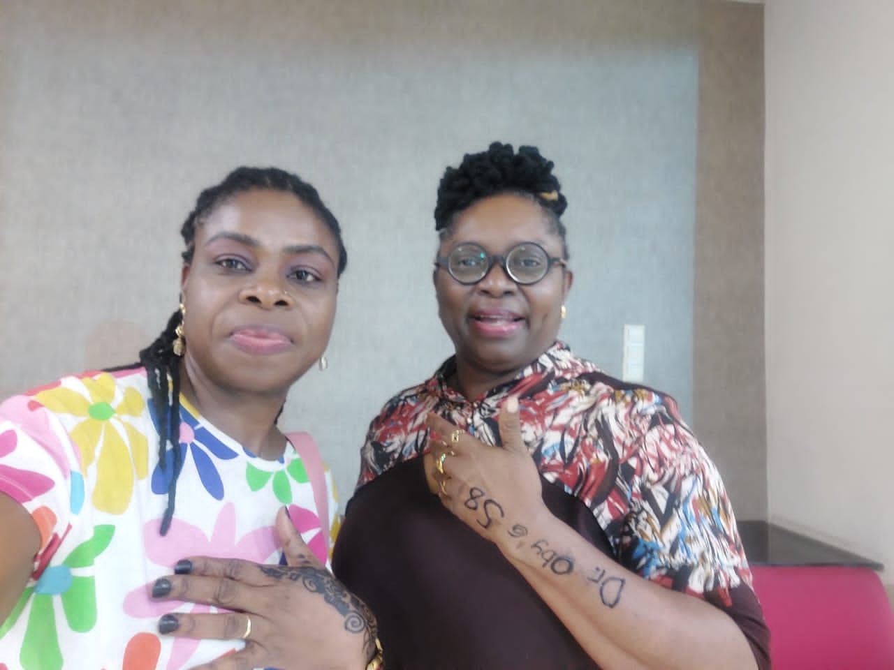 A selfie of Dr. Oby Nwokedi with a colleague, her forearm signed in ink: “Dr. Oby @ 58”