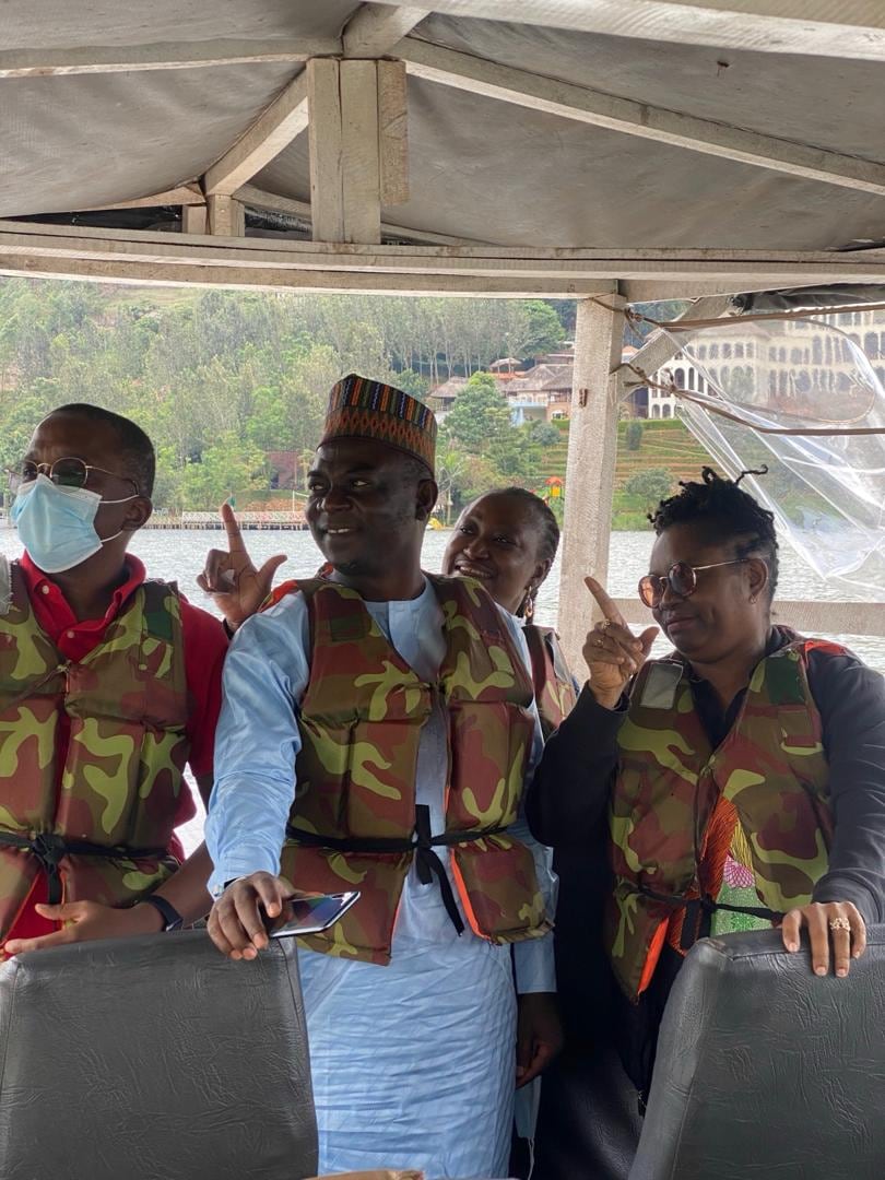 Dr. Oby Nwokedi and colleagues in life jackets on a covered boat, pointing ahead