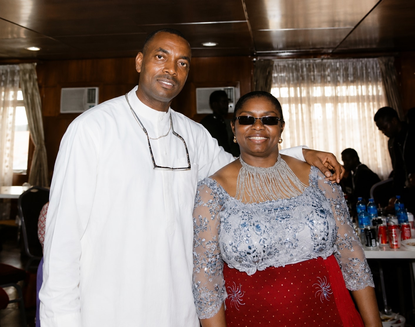 Dr. Oby Nwokedi with her husband, his arm around her, he in white and she in blue lace