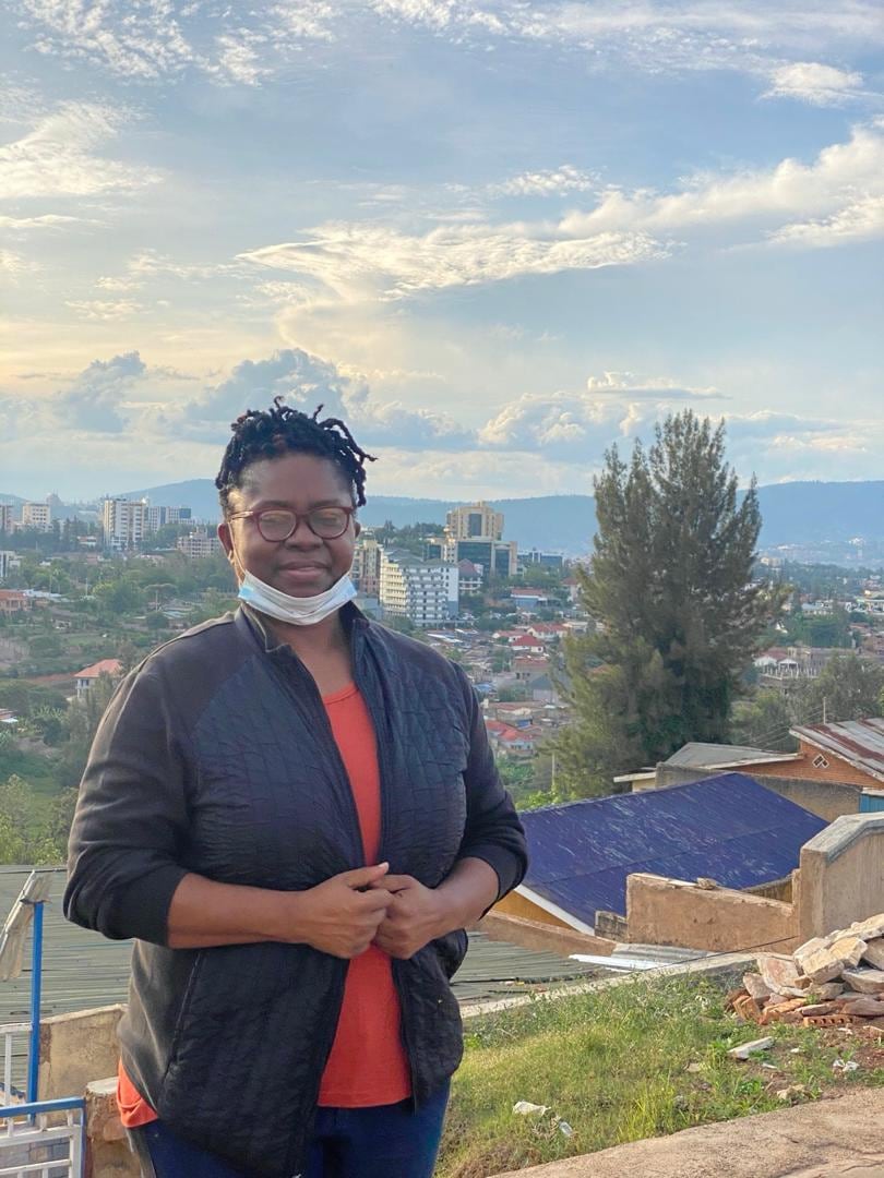Dr. Oby Nwokedi before a hillside city at dusk