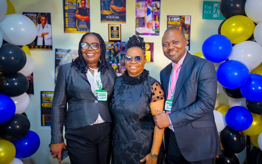 Dr. Oby Nwokedi standing between two colleagues wearing staff lanyards